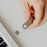 Photographie d'une clef usb blanche qui s'apprête à être branché à un ordinateur